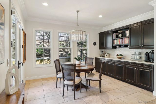 a kitchen with stainless steel appliances granite countertop a stove a sink dishwasher a dining table and chairs with wooden floor