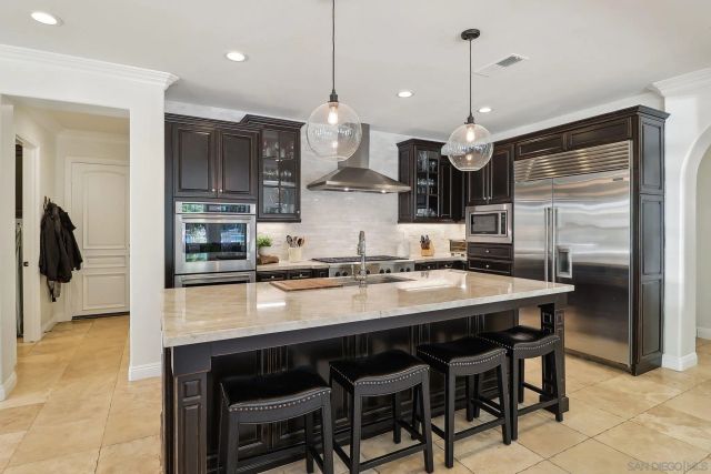 a kitchen with stainless steel appliances granite countertop a sink a stove and a refrigerator