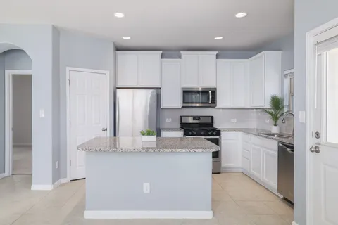 a kitchen with stainless steel appliances granite countertop a stove sink and cabinets