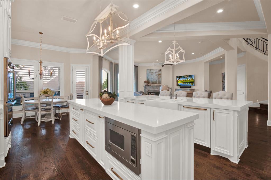 2921 Sedalia Trail Sherman, TX 75092 - Photo 14 of 40 a large white kitchen with a large island oven a stove a dining table and chairs
