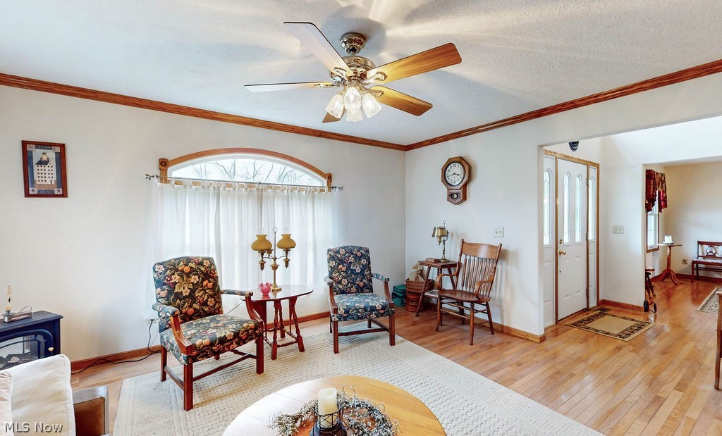 10147 Page Road Streetsboro, OH 44241 - Photo 17 of 35 Living area with light hardwood / wood-style floors, ceiling fan, a textured ceiling, and crown molding