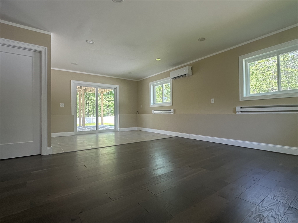 102 Wells Road Becket, MA 01223 - Photo 21 of 40 an empty room with wooden floor and windows