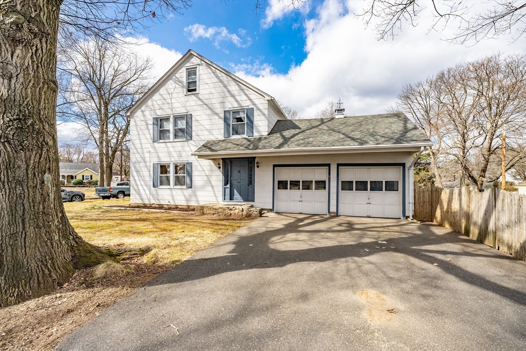 94 Holly Street Springfield, MA 01151 - Photo 1 of 41 a view of a white house with a large tree and wooden fence