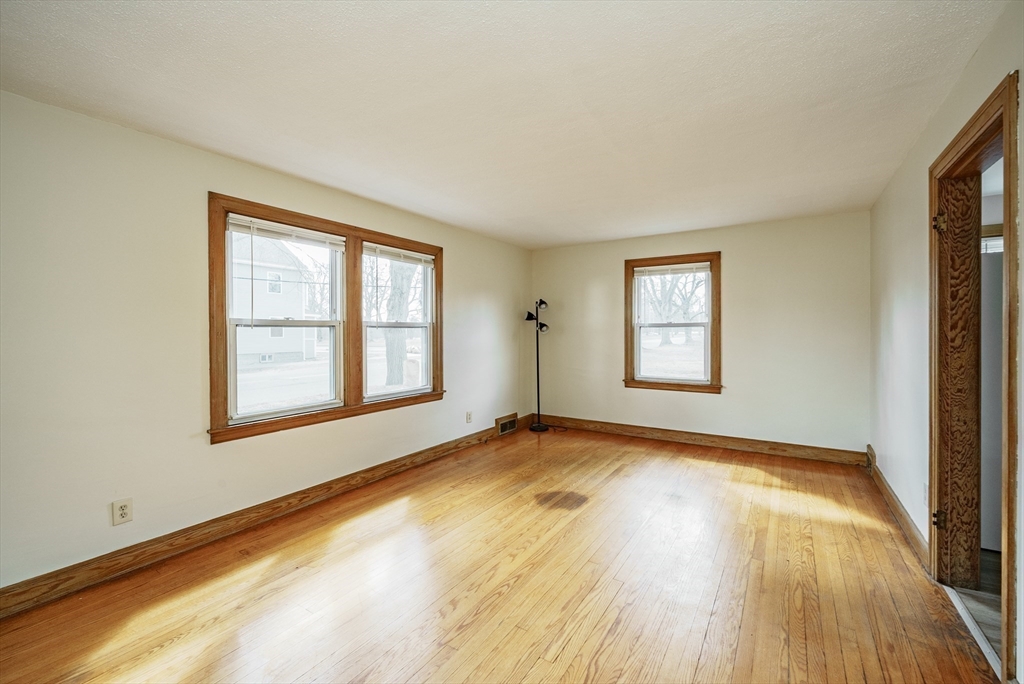 94 Holly Street Springfield, MA 01151 - Photo 3 of 41 a view of an empty room with wooden floor and a window