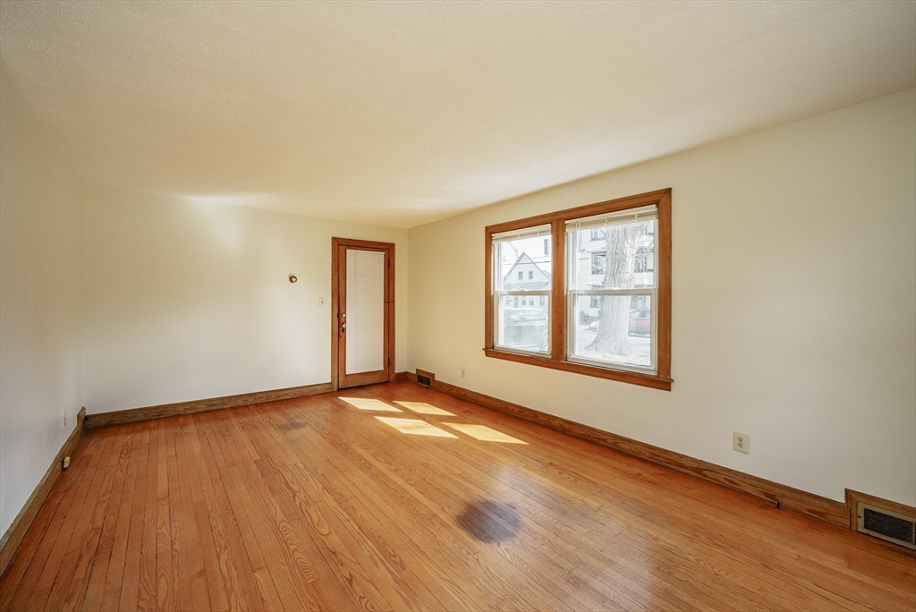 94 Holly Street Springfield, MA 01151 - Photo 5 of 41 a view of an empty room with wooden floor and a window