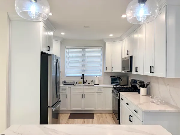 a kitchen with stainless steel appliances kitchen island a sink refrigerator and cabinets