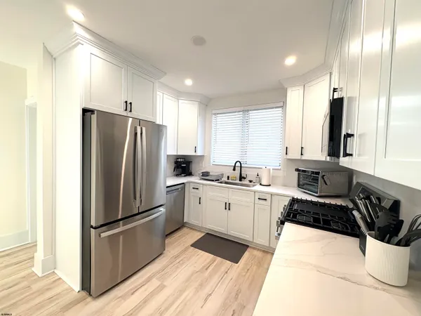 a kitchen with a refrigerator a sink and cabinets