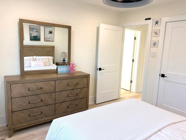 a bedroom with a bed and a mirror on the dresser