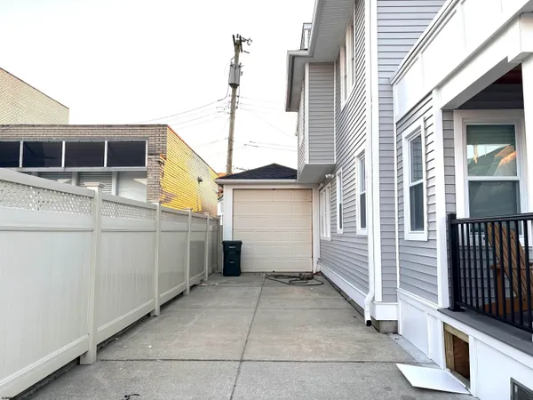 a view of a house with a barbeque and wooden stairs