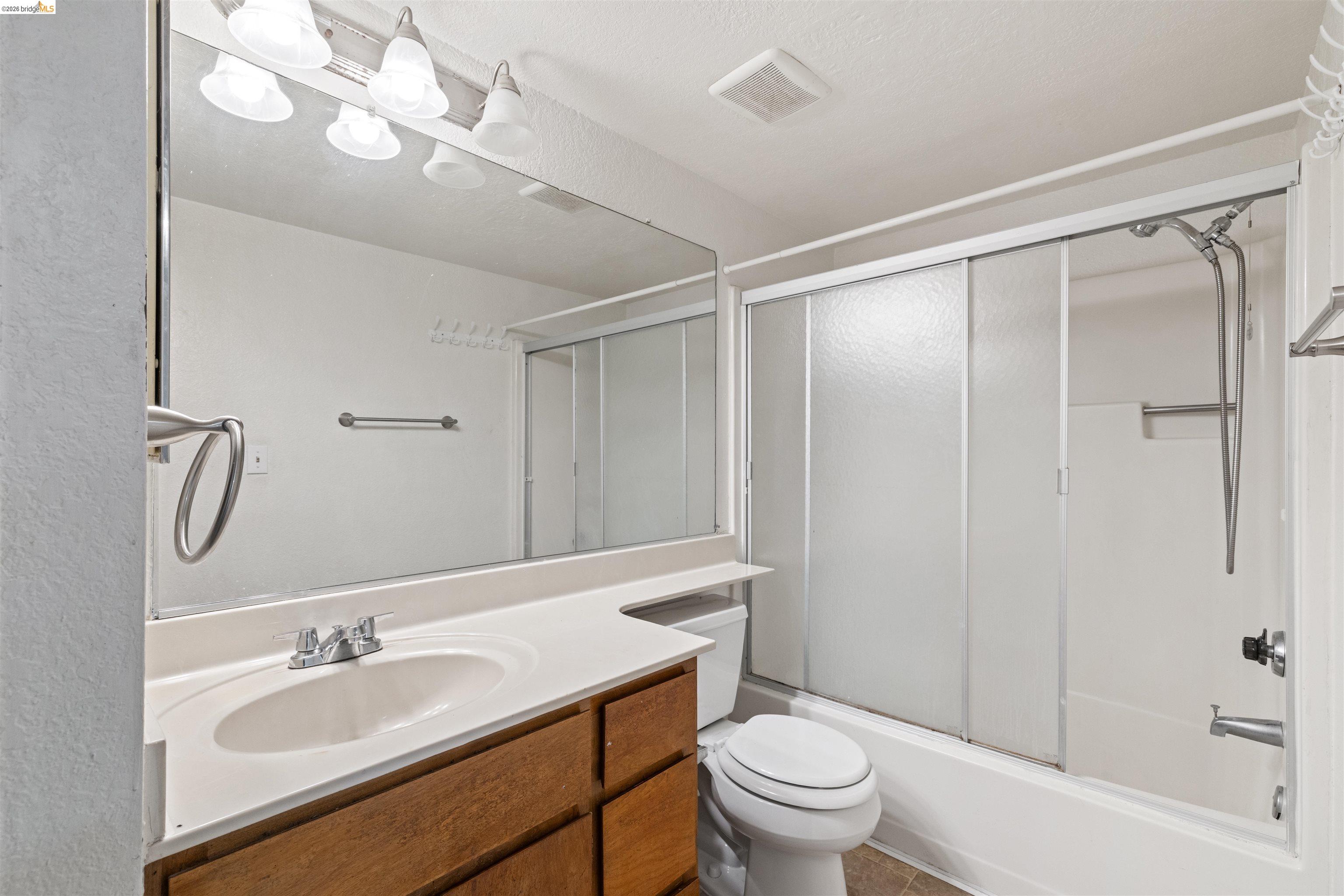 1151 Chadwick Circle Bay Point, CA 94565 - Photo 18 of 23 Bathroom featuring an integrated sink with a chrome faucet, wood-finish vanity, and a large wall-mounted mirror