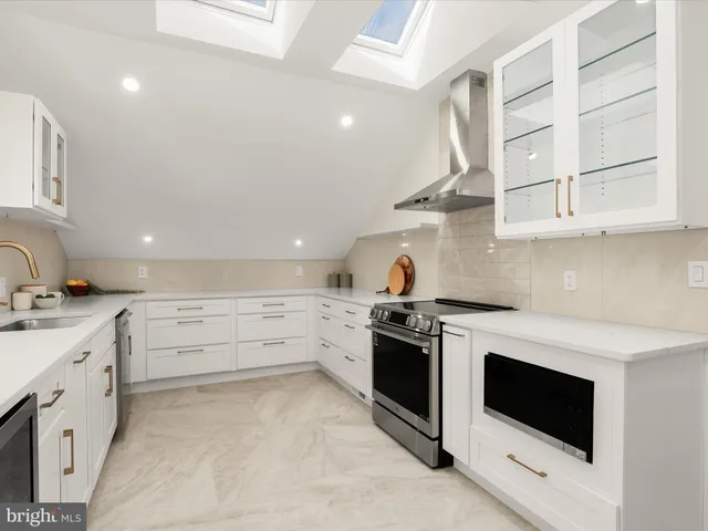 a kitchen with granite countertop white cabinets and white appliances