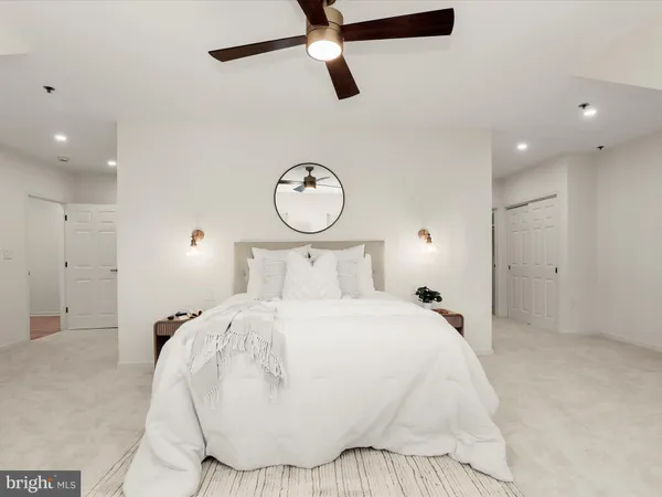 a bedroom with a large bed and a chandelier