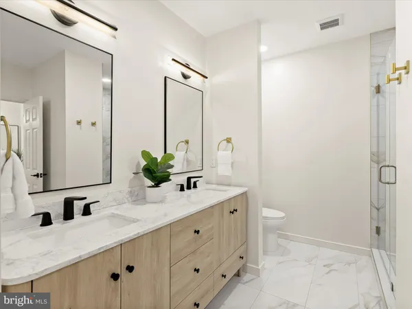 a bathroom with a granite countertop sink a toilet and a large mirror