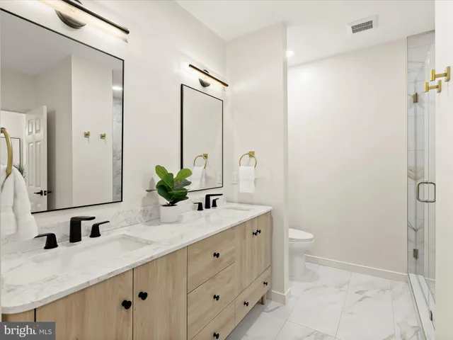 a bathroom with a granite countertop sink a toilet and a large mirror