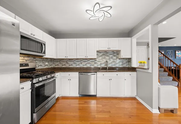a kitchen with stainless steel appliances granite countertop a stove and cabinets