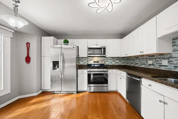 a kitchen with cabinets stainless steel appliances and window