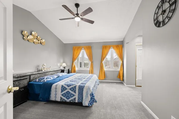 a bed sitting in a spacious bedroom next to a window