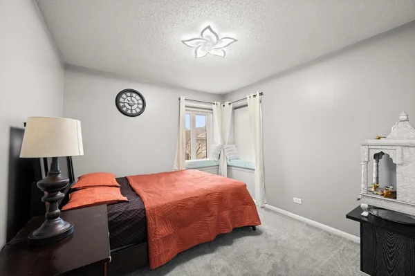 a bedroom with a bed and a lamp on the dresser