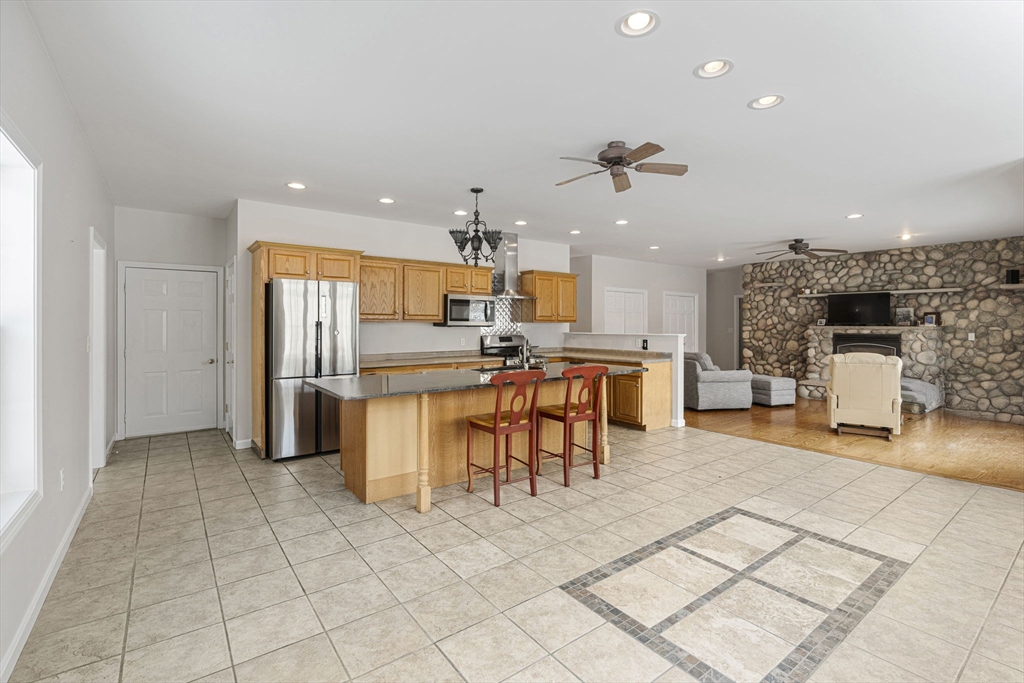 95 Wright Road Hollis, NH 03049 - Photo 4 of 42 a kitchen with stainless steel appliances kitchen island granite countertop a refrigerator and a sink
