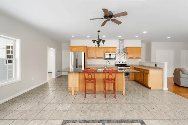 a kitchen with stainless steel appliances kitchen island granite countertop a sink cabinets and microwave