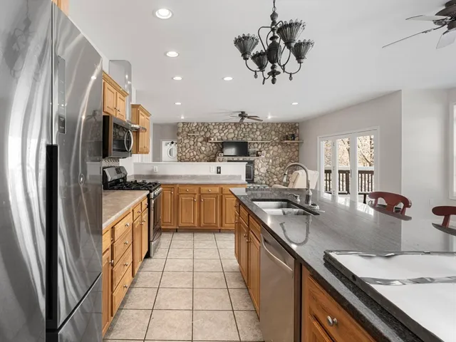 a kitchen with stainless steel appliances granite countertop a sink a stove and a refrigerator