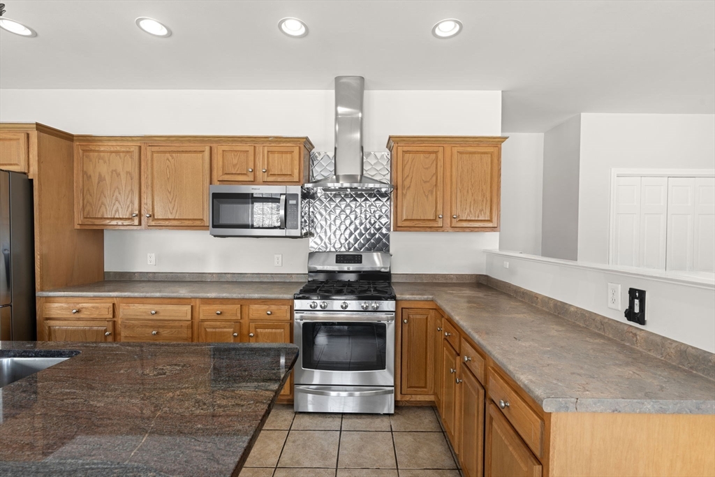 95 Wright Road Hollis, NH 03049 - Photo 8 of 42 a kitchen with stainless steel appliances granite countertop a stove a sink and a microwave