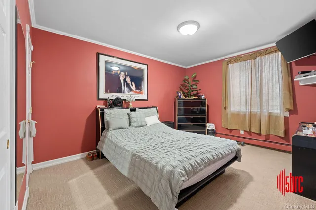 a bedroom with a bed and a dresser next to a window