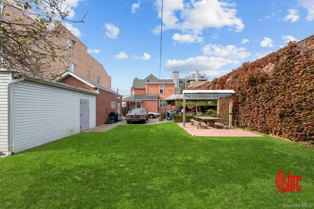a patio with table and chairs with plants and garden
