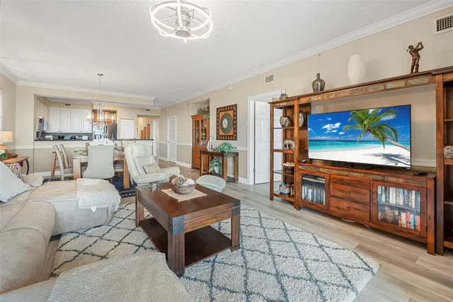 a living room with furniture a flat screen tv and a dining table