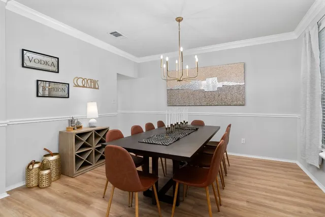 a view of a dining room with furniture wooden floor and chandelier
