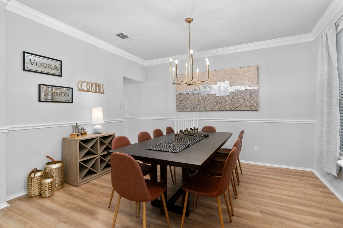 807 Clarence Bohl Pflugerville, TX 78660 - Photo 11 of 40 a view of a dining room with furniture wooden floor and chandelier