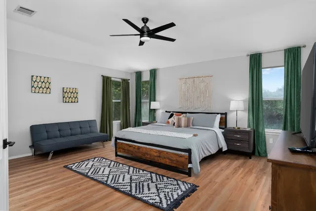 a bedroom with a bed a couch and a window