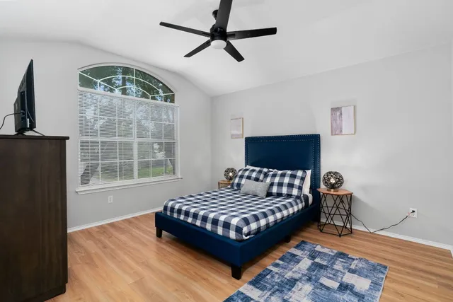 a bedroom with a bed and wooden floor