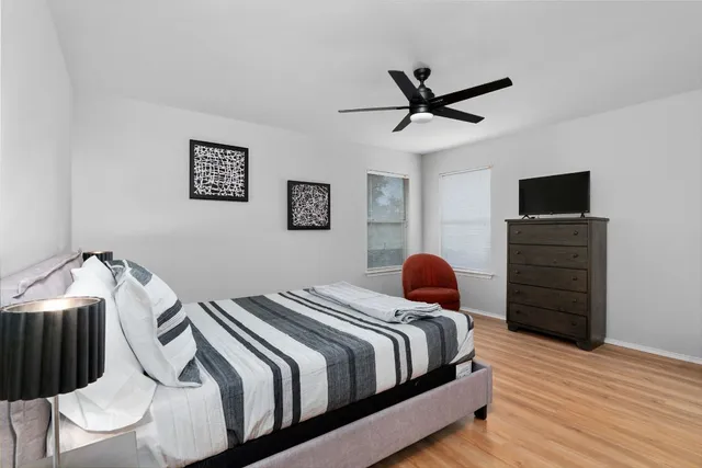 a bedroom with a bed and a tv on dresser