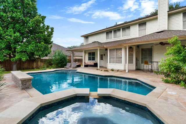 a view of a patio with couches table and chairs with potted plants and big yard