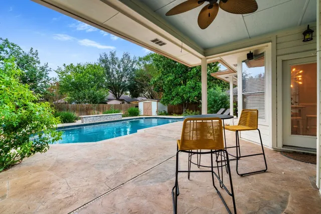 a view of patio with a table and chairs under an umbrella