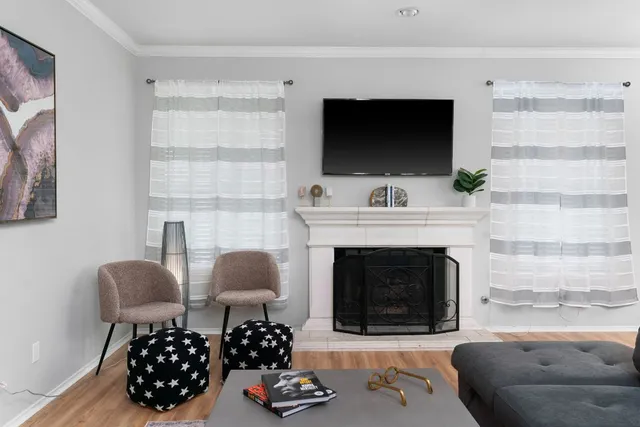a living room with furniture a flat screen tv and a fireplace