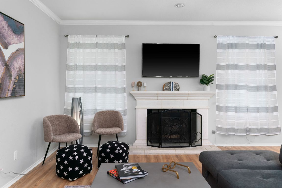 807 Clarence Bohl Pflugerville, TX 78660 - Photo 4 of 40 a living room with furniture a flat screen tv and a fireplace