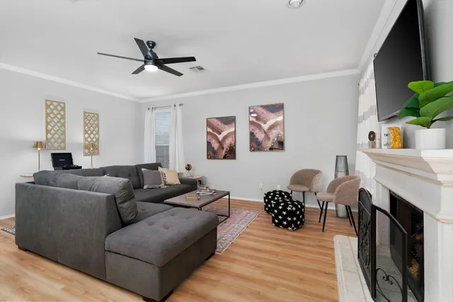 a living room with furniture a fireplace and a flat screen tv