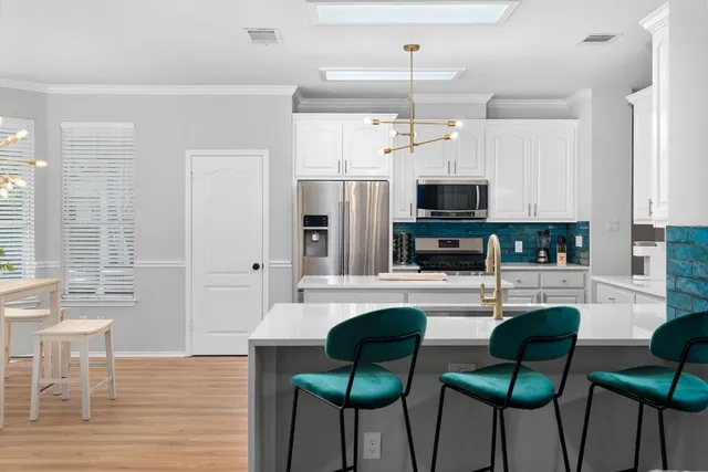 a kitchen with granite countertop a stove and chairs