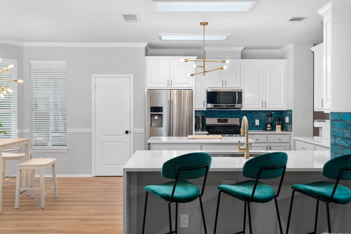 807 Clarence Bohl Pflugerville, TX 78660 - Photo 6 of 40 a kitchen with granite countertop a stove and chairs
