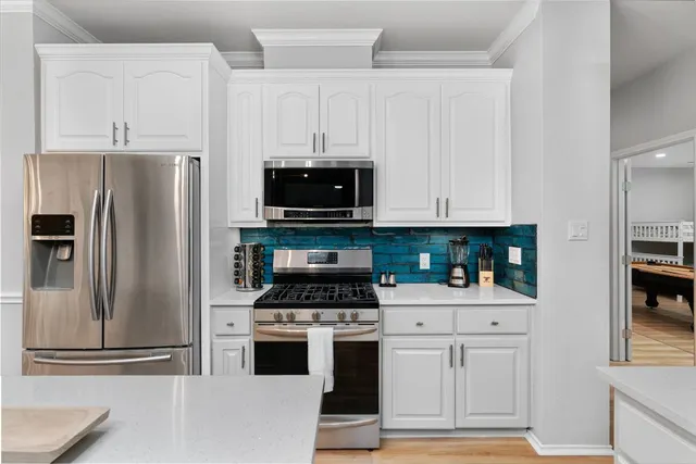 a kitchen with white cabinets and stainless steel appliances