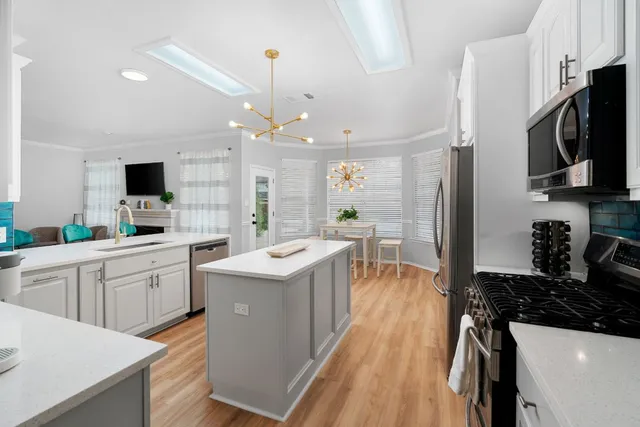 a kitchen with counter top space a sink stainless steel appliances and cabinets