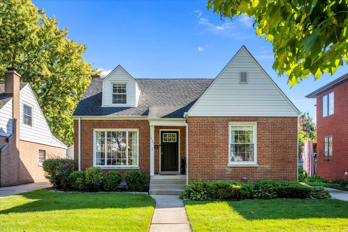 a front view of a house with yard and green space