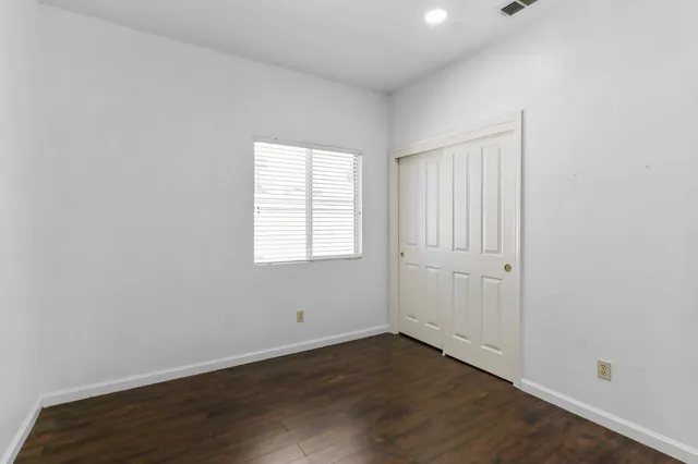 an empty room with wooden floor and mirror