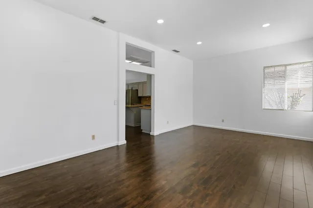 an empty room with wooden floor and a window