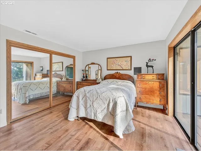 a bed sitting in a spacious bedroom next to a window