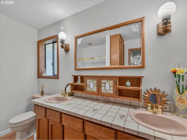 a bathroom with a granite countertop sink a mirror and a shower