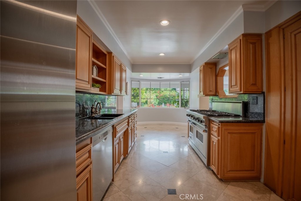 15363 Victory Boulevard Van Nuys, CA 91406 - Photo 15 of 52 a kitchen with stainless steel appliances granite countertop a stove a sink and a refrigerator