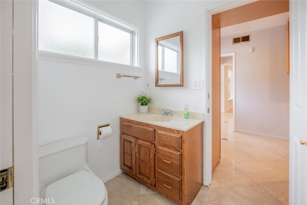 15363 Victory Boulevard Van Nuys, CA 91406 - Photo 25 of 52 a bathroom with a toilet a sink and a mirror